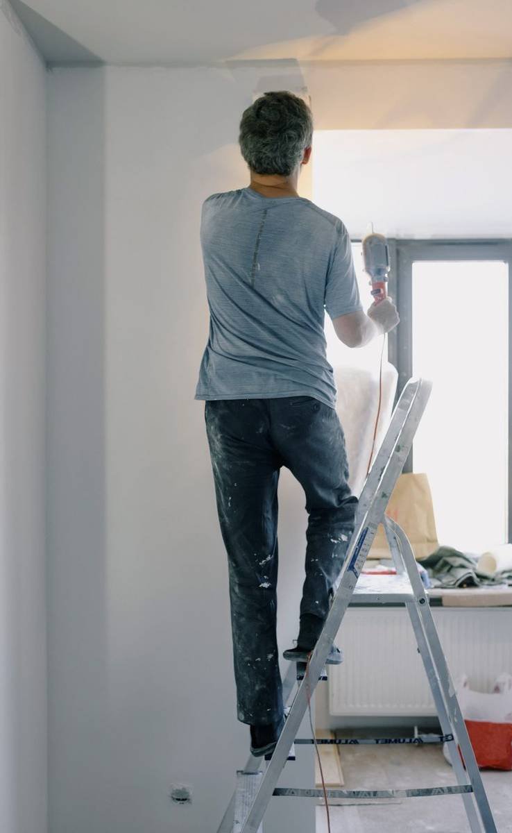 Maler streicht eine Wand weiss